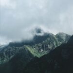Mountain Landscapes - Fog-covered green mountains with a dramatic sky #10259424