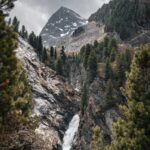 Mountain Landscapes - Discover the scenic waterfall amidst pine trees #12643375