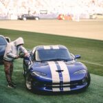 Luxury Cars - Blue sports car with racing stripes showcased ou #34444968