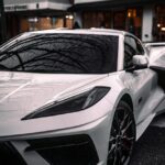 Luxury Cars - A sleek white sports car in front of urban build #34819083