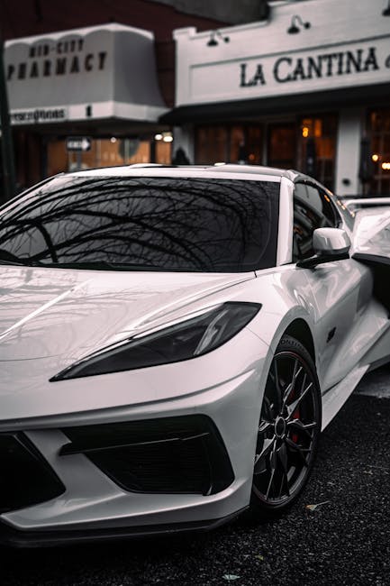 Luxury Cars - A sleek white sports car in front of urban build #34819083