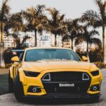 Luxury Cars - Vibrant yellow sports car parked outdoors agains #6867272